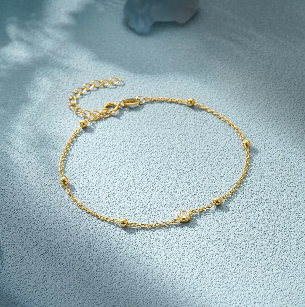 Dünnes 18 Karat vergoldetes Armband mit Zirkonauge und Perlen